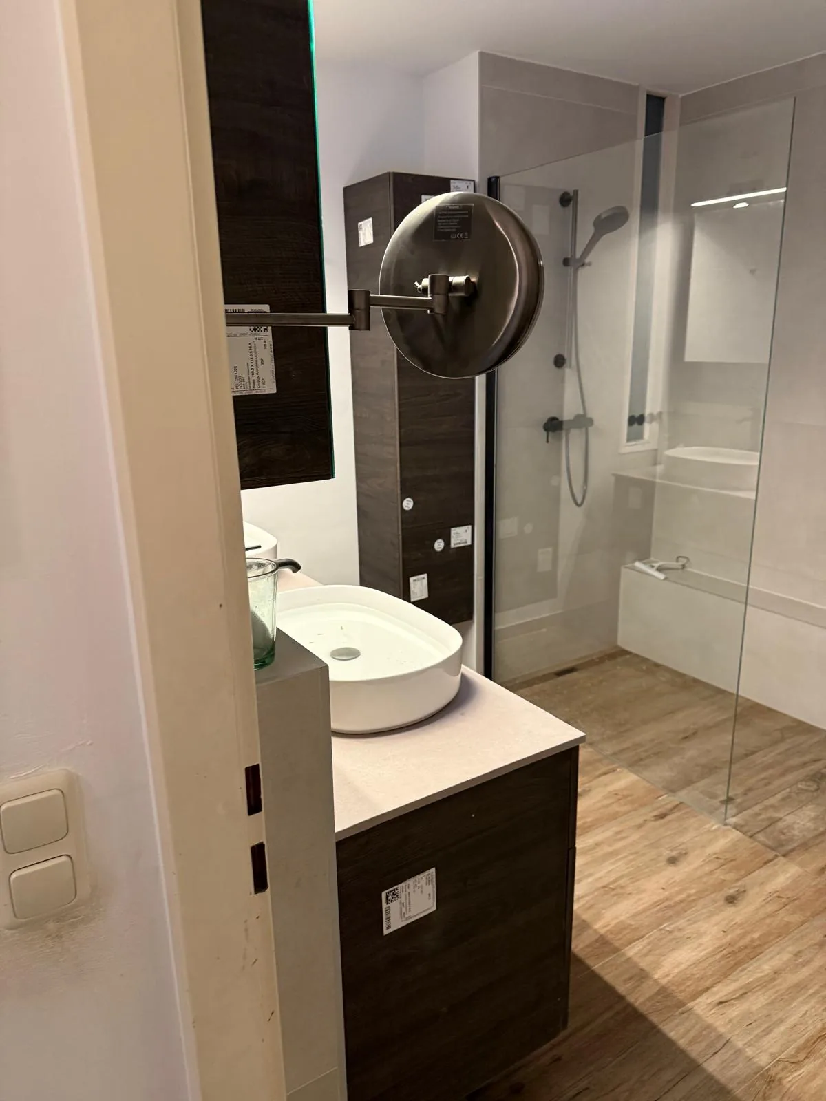 Badezimmer mit Dusche, Waschtisch und Holzoptik