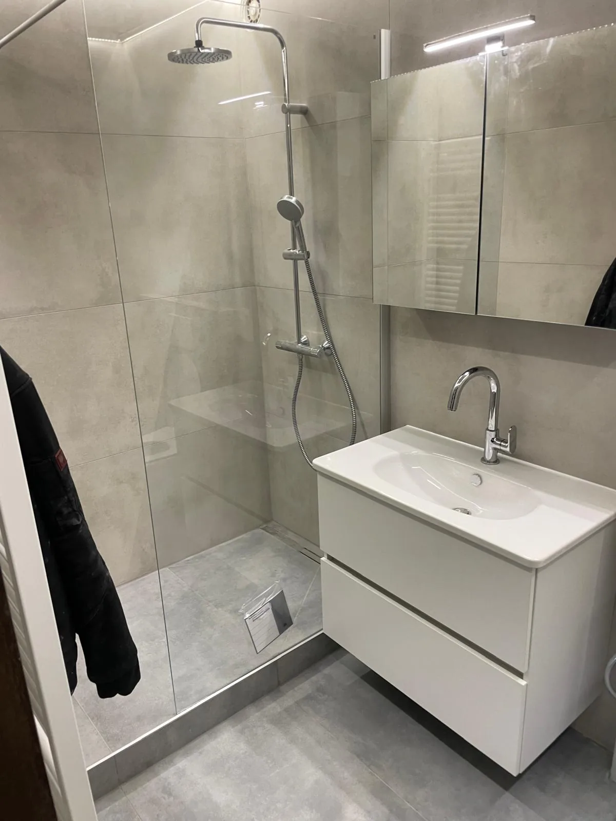 Modernisiertes Badezimmer mit Glasdusche und Waschtisch
